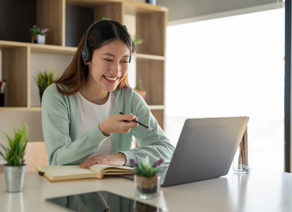Frau mit Headset auf Kopf am Laptop